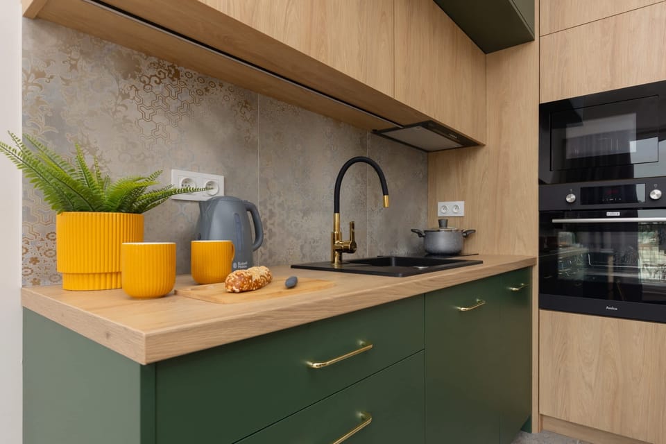 Another perspective of the kitchen, emphasizing its green and wood finish and stylish appliances.
