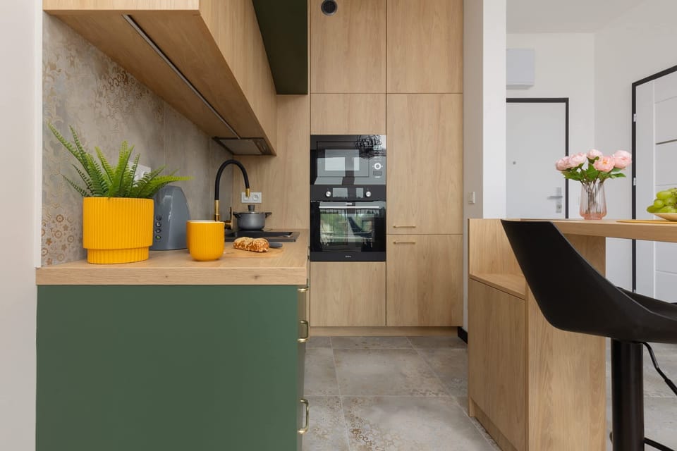 A close-up of the kitchen, featuring vibrant yellow decor accents and modern cooking essentials.

