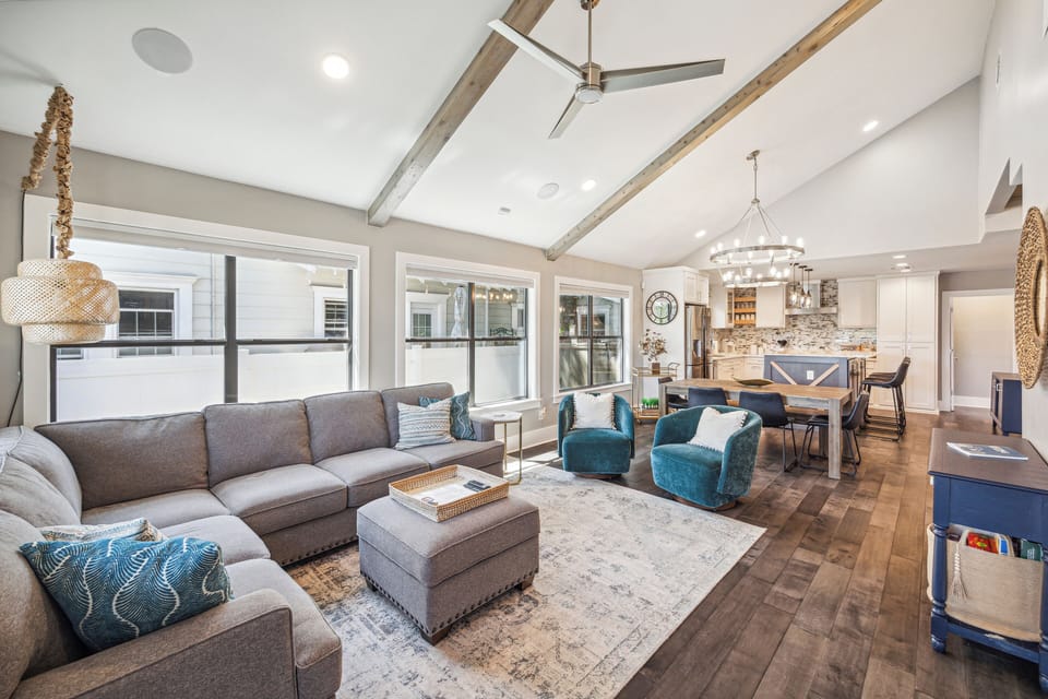 Large L shaped couch with swivel chairs open to the kitchen and living room.