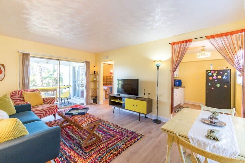 Bright living room with colorful furniture and access to a screened porch.