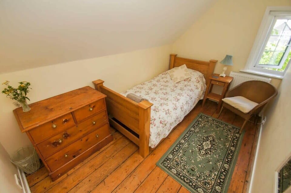 Bedroom 2

Single bedroom on the first floor with occasional chair, chest of drawers, bedside table and lamp.