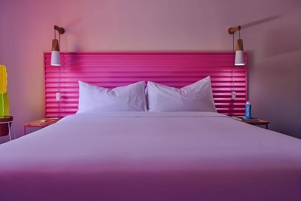 Sink into cloud-soft linens beneath warm, designer bedside lighting.