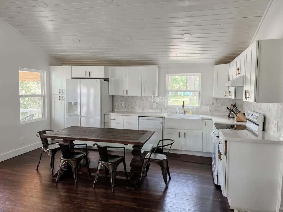 Kitchen table has seating for 7 and doubles as an island/prep area.