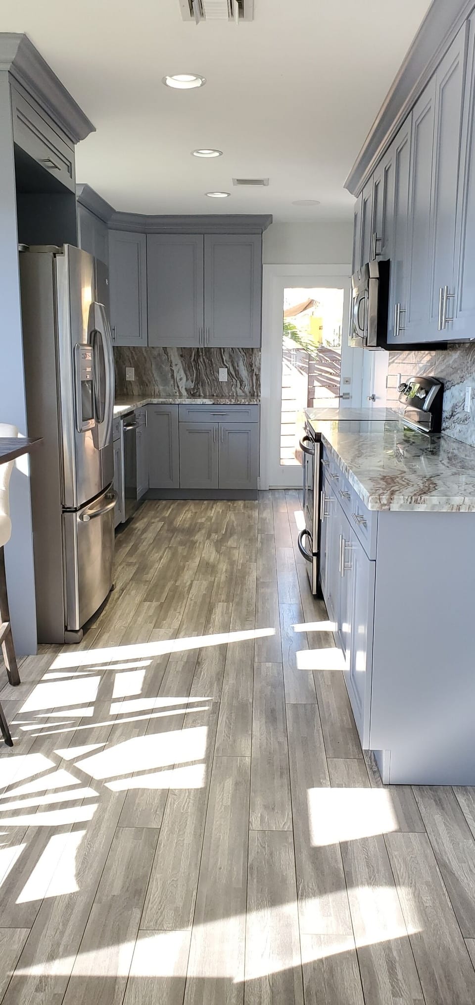 Custom kitchen featuring granite countertops, stainless-steel appliances. 