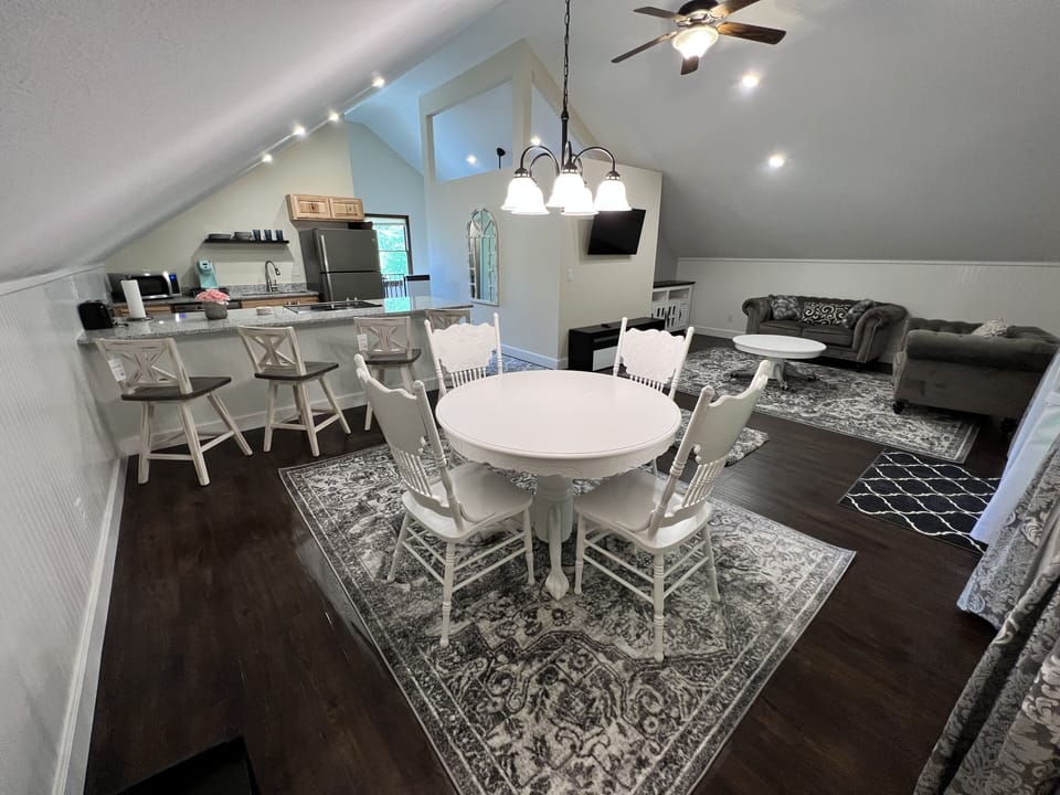 Open concept with dining, living room, and large granite seating while cooking.
