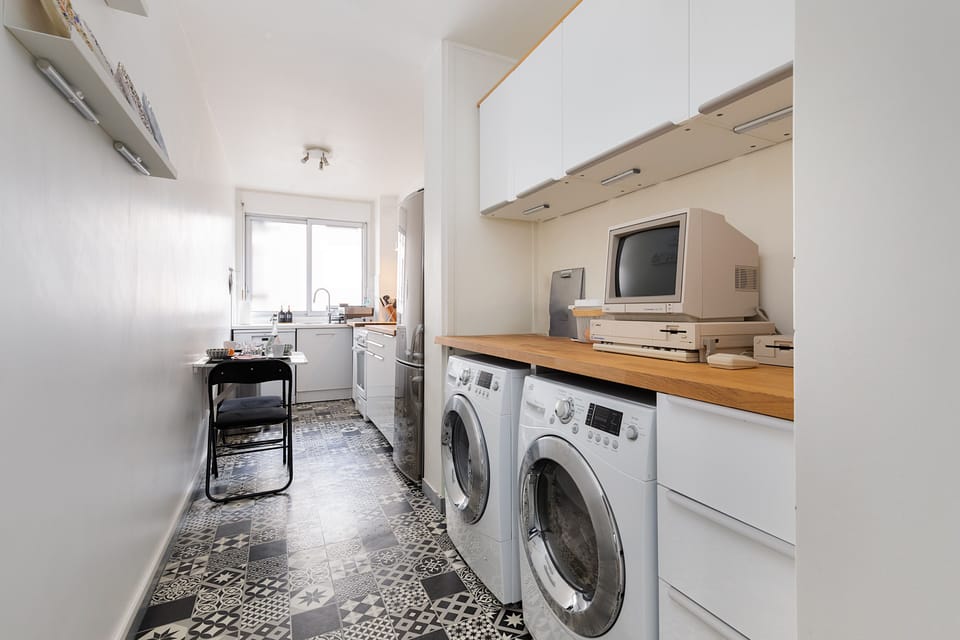 Functional kitchen space with a washing machine and dryer.