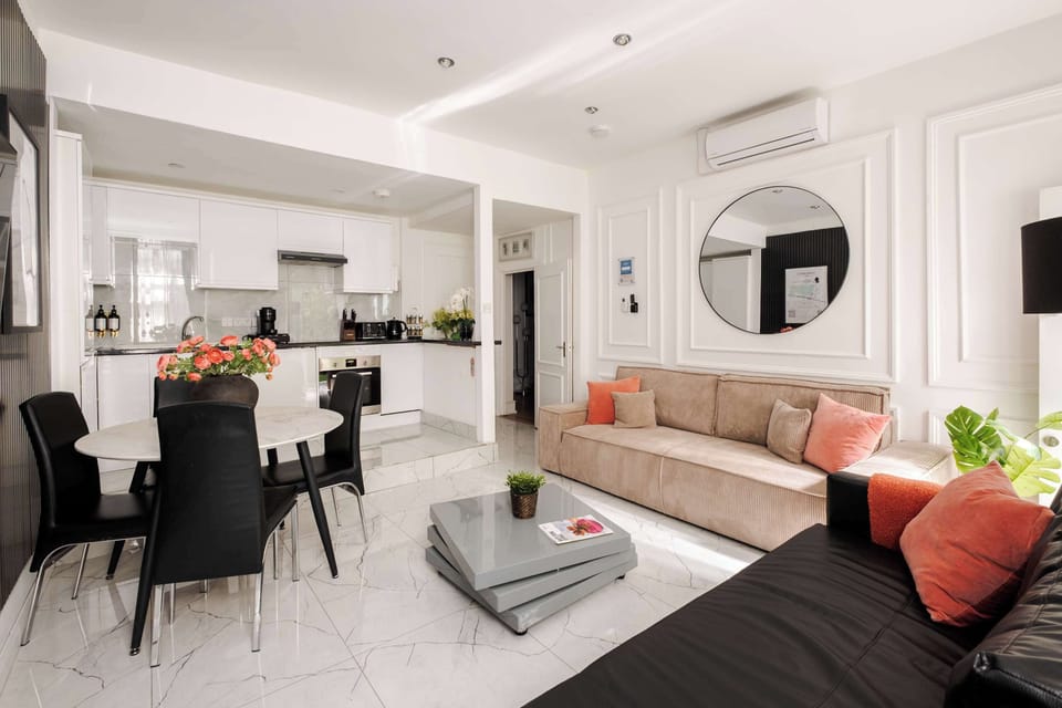 Living Room | Enjoy the spacious luxury of our living room, adorned with high ceilings and an open-plan kitchen for a sense of grandeur. Relax in front of the smart 65-inch TV with a PS5 and stay comfortable with our advanced air conditioning system.