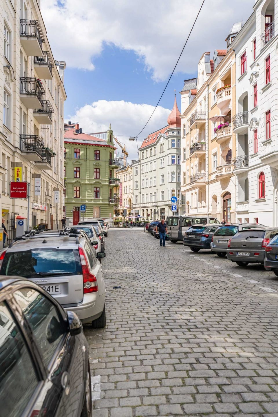 A street view of the surrounding neighborhood, showcasing classic European architecture and a lively atmosphere.
