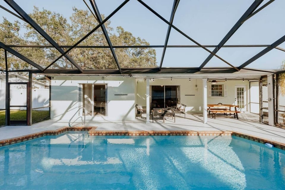 Enjoy the large, deep swimming pool with seating shelves, outdoor dining, and lounge area