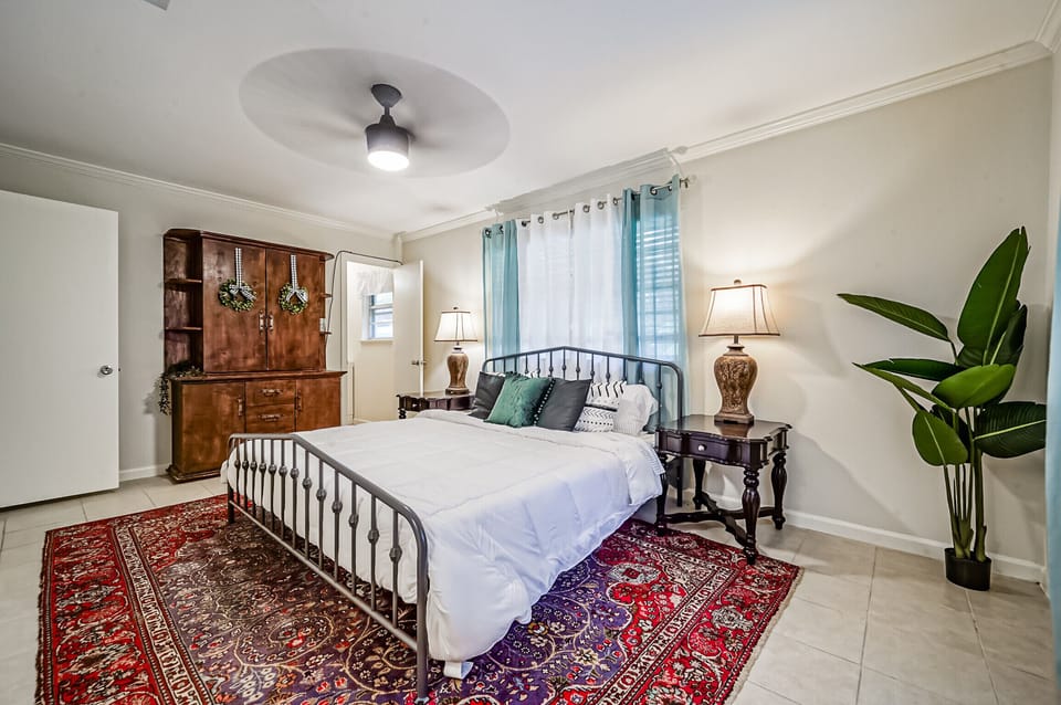 Primary bedroom view with king-sized bed, armoire, ensuite bathroom 