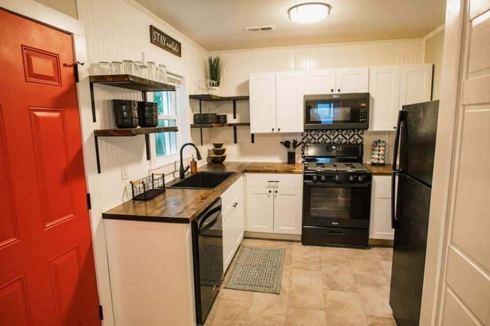 Beautifully renovated kitchen. Butcher block counter tops, open shelving, and retro tile backsplash lend themselves perfectly to the farmhouse style design of this home. 