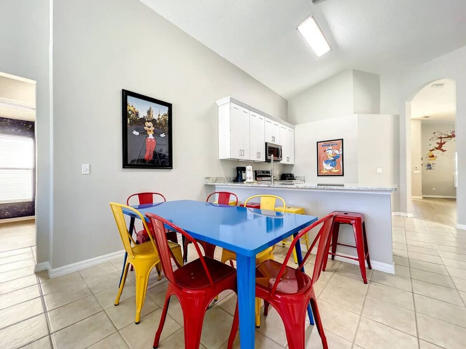 Colorful and fun dining area with a retro vibe, featuring bold primary-colored seating and playful wall art—perfect for family meals or entertaining in style.