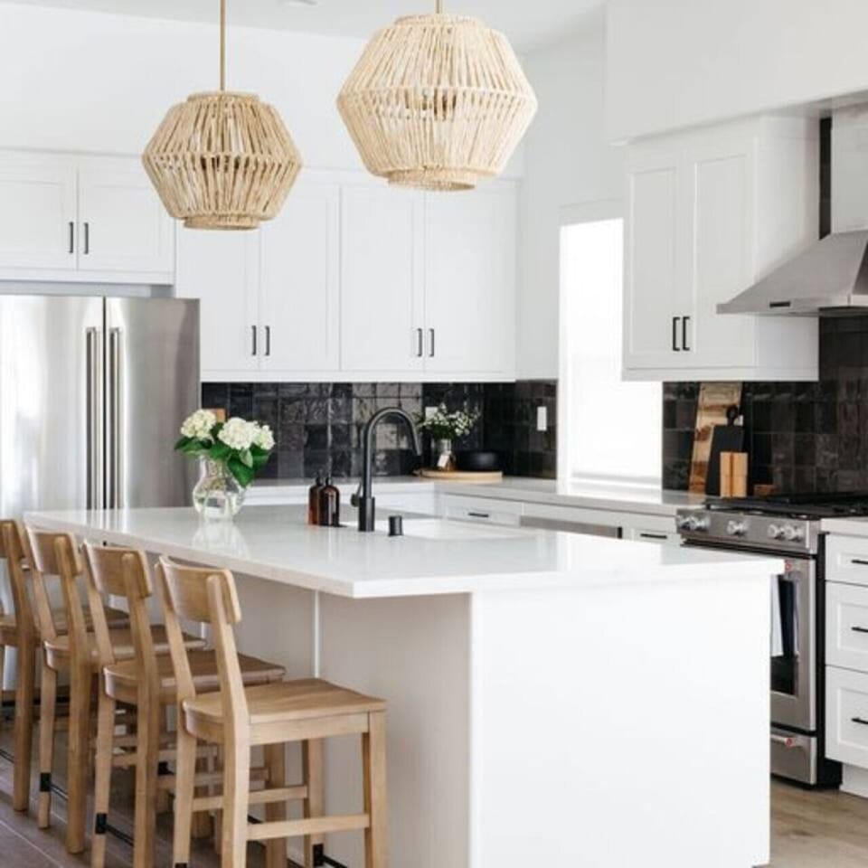Modern kitchen w/ sleek white cabinetry, island seating & stainless appliances