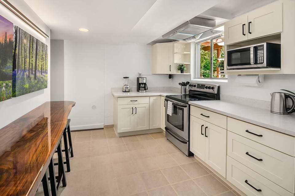 The kitchen features a unique 10 foot walnut live-edge bar which seats 6 people.