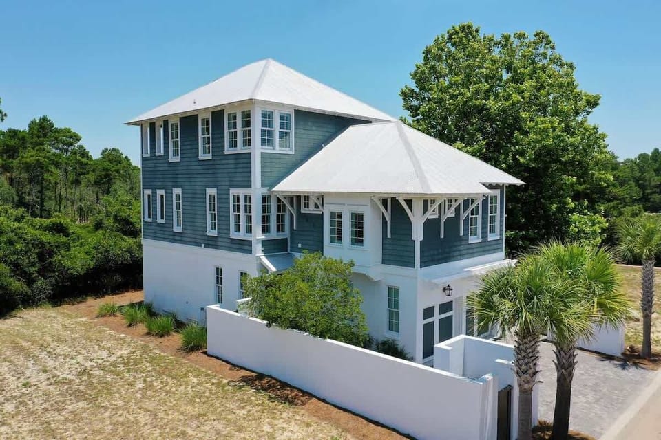 - Gorgeous beach house with crisp white trim & coastal blue siding, framed by beautiful palms - Three story design offers space, comfort, & elevated views throughout your stay - Private entry & fenced courtyard create a peaceful coastal retreat