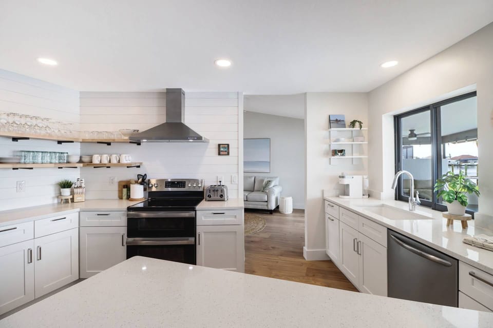 The kitchen is a delight with quartz counters, upgraded appliances, open wood shelving and a bright modern farmhouse design.