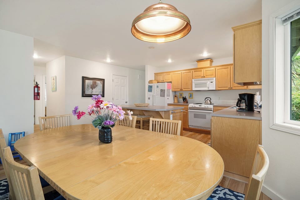 Your open-concept kitchen and dining space invites effortless gatherings, with a spacious round table and warm wood tones setting the scene for memorable meals together.