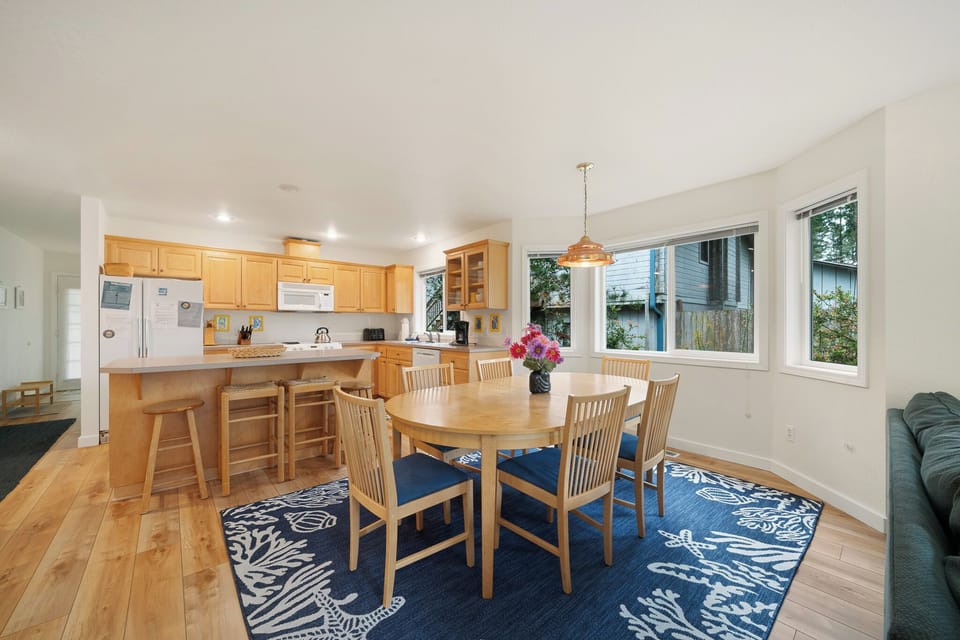 Your open kitchen and dining area blends warm wood cabinetry with abundant natural light, creating a welcoming space for meals and gatherings.