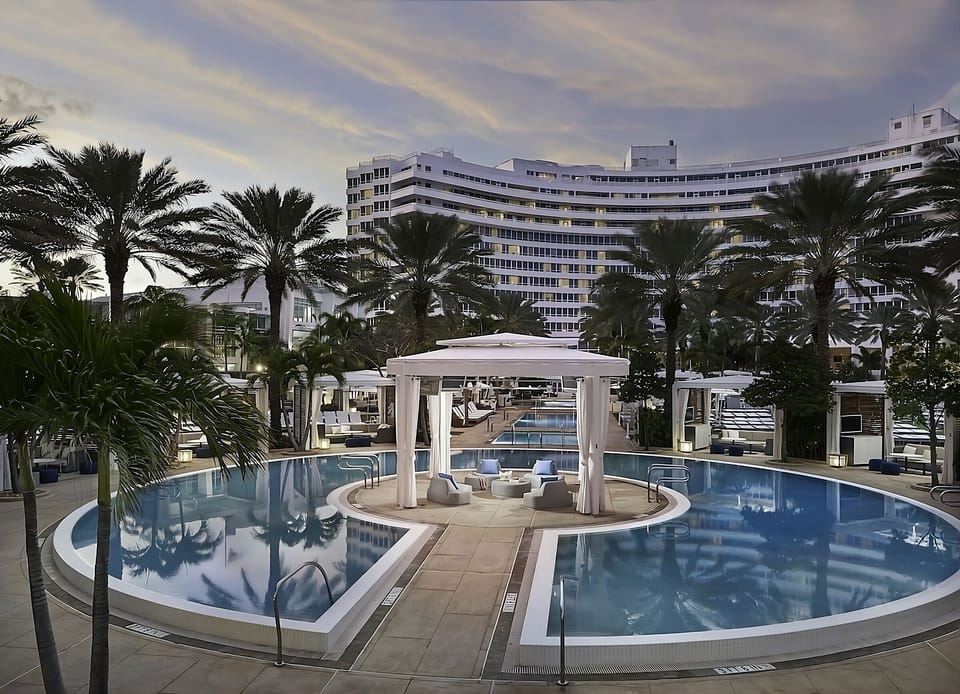 Unwind at the glowing resort pool as evening settles.