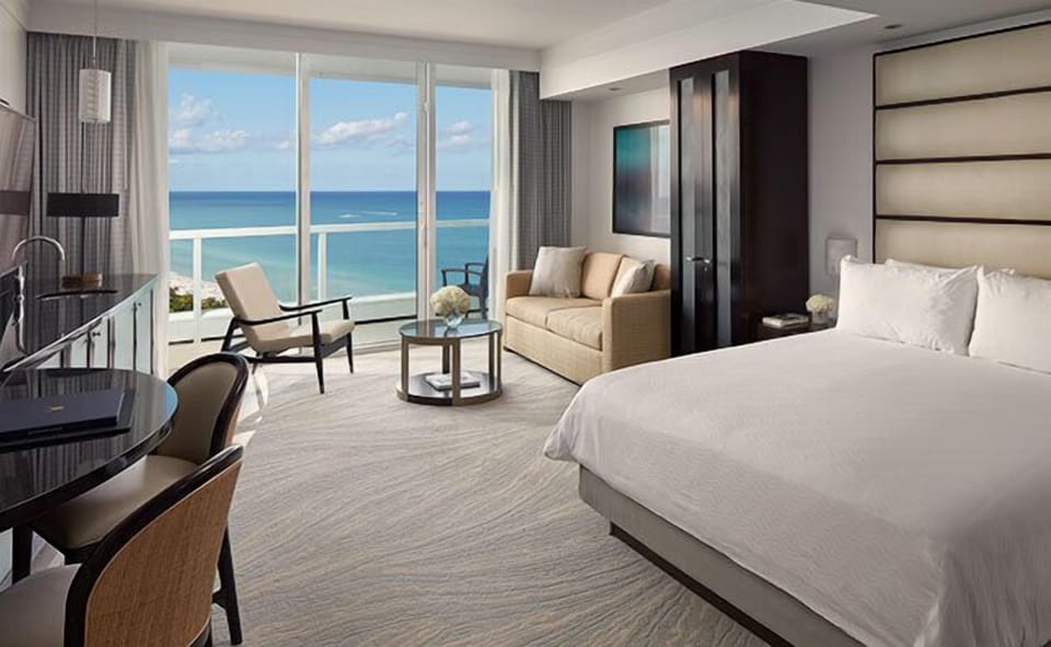 Lounge beside floor-to-ceiling windows with endless ocean views.