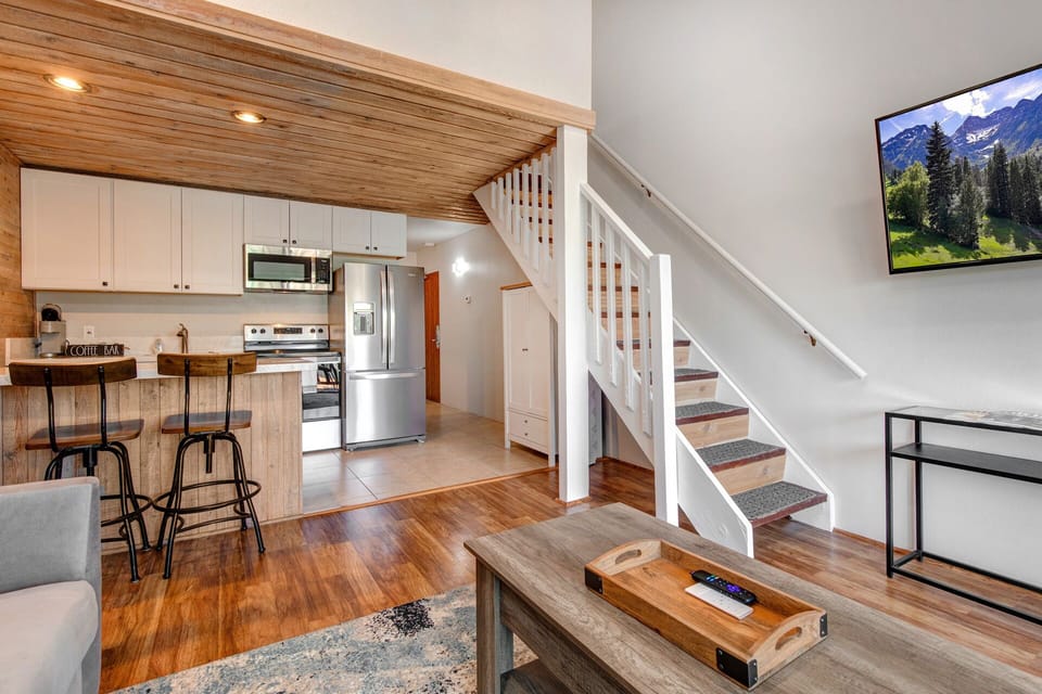 Cozy space with sofa bed, center table, and loft bedroom access.