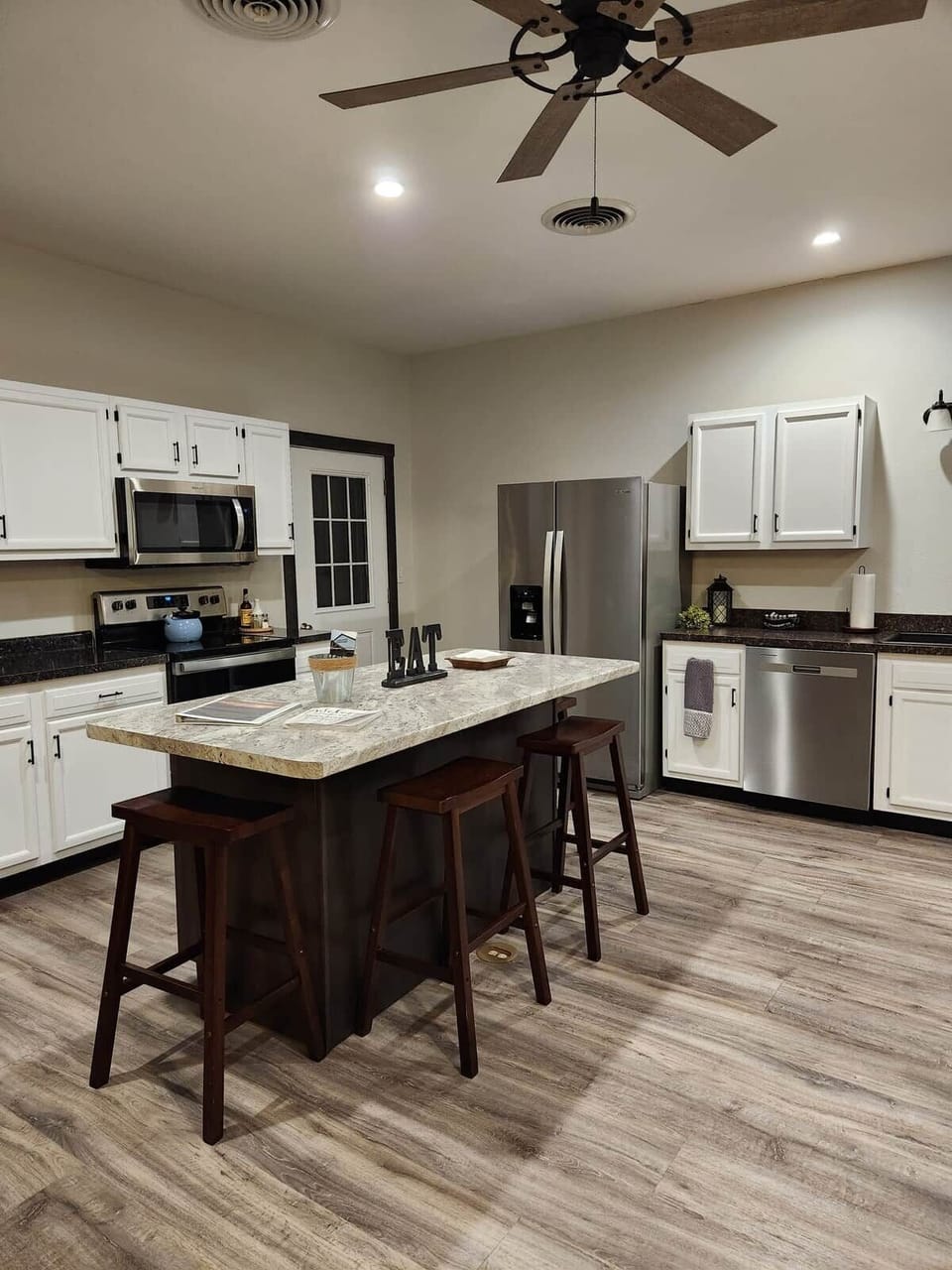 Full Kitchen with island bar and stainless steel appliances.