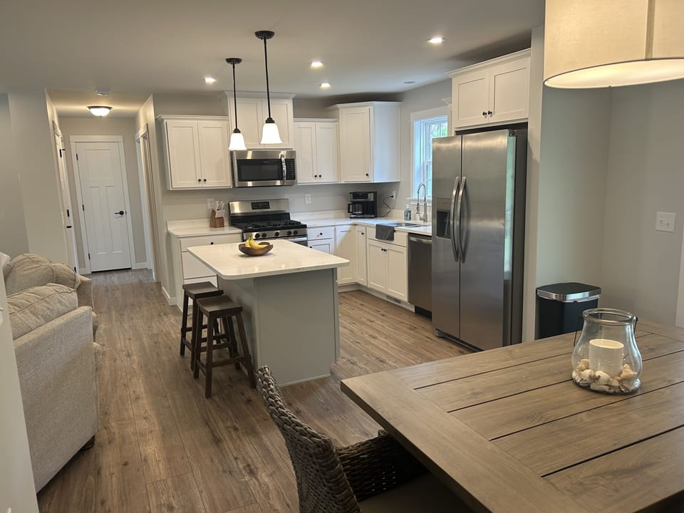 Kitchen and dining area with hallway leading to other 2 bedrooms and bathroom. 