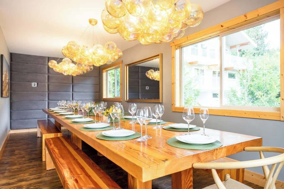 - Long wooden dining table with artistic chandeliers creating a warm glow  
- Perfect for family dinners or group celebrations with scenic outdoor views  
- Elegant yet inviting dining space designed for laughter and shared meals  
