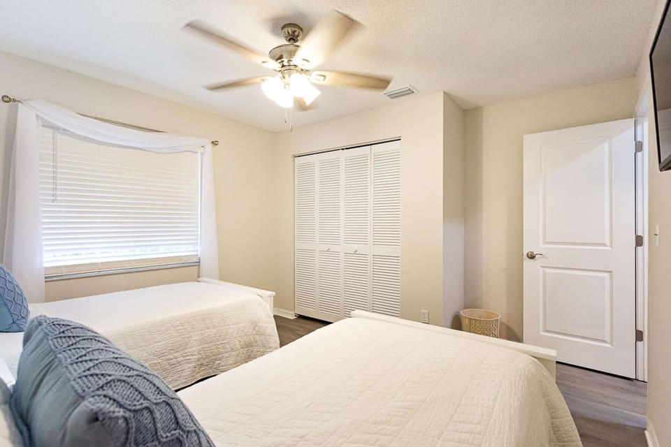 Second bedroom with 2 twin beds, closet and tv