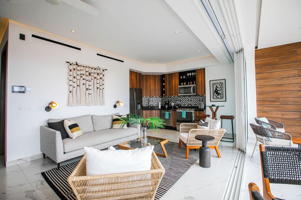 Bright, modern living space with warm wood tones and contemporary design. Relax on the plush sofa, dine in style, or step outside to your private seating area.