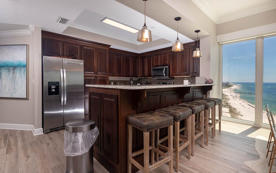 Savor morning coffee while enjoying panoramic coast views from the inviting bar seating in this beautiful kitchen