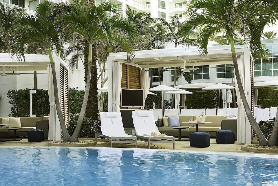 Lounge poolside in shaded cabanas with breezy tropical calm.