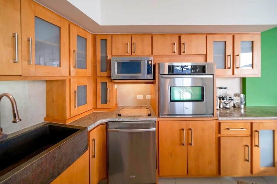 Fully equipped with stainless steel appliances and a copper sink.