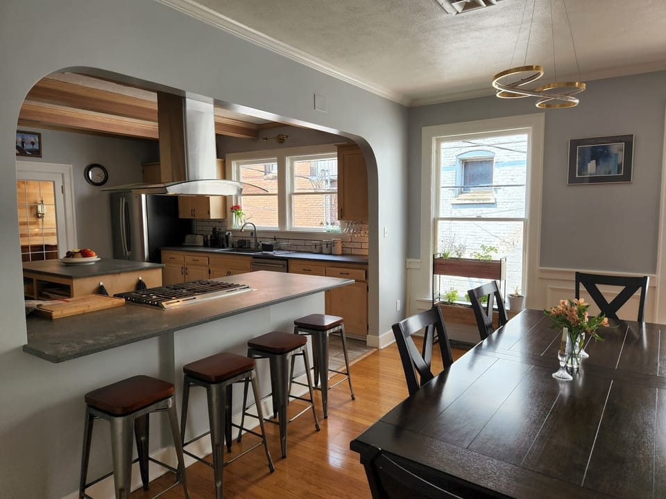 Hall entry across bar, table and alley windows, mobius dining chandelier. 