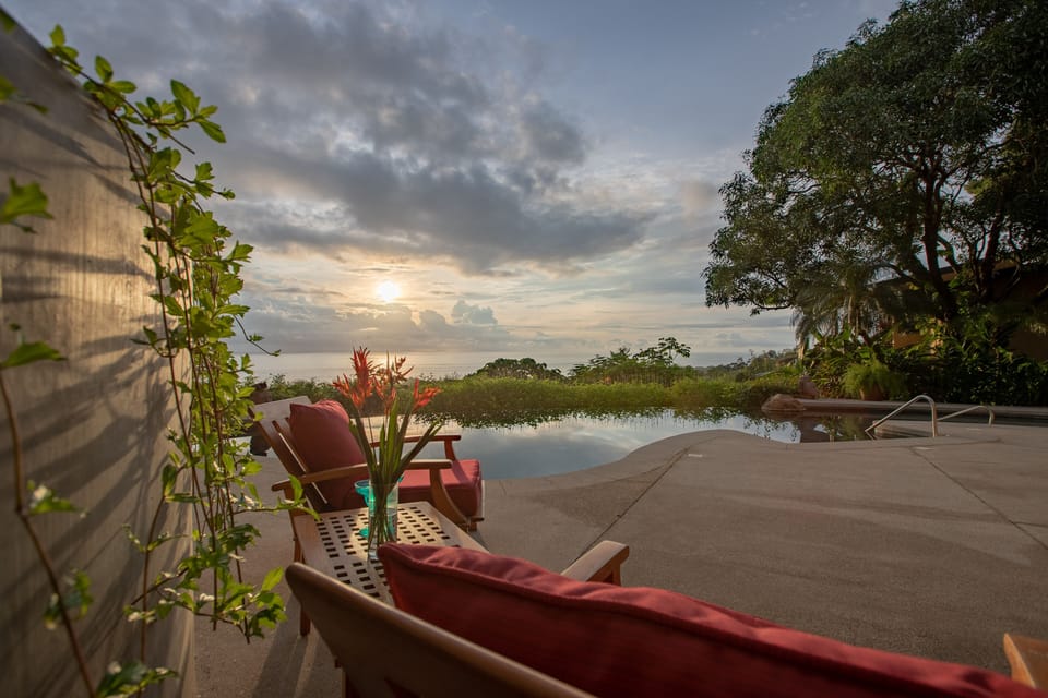 View of pool and ocean from terrace below the main house. Ourdoor furniture.