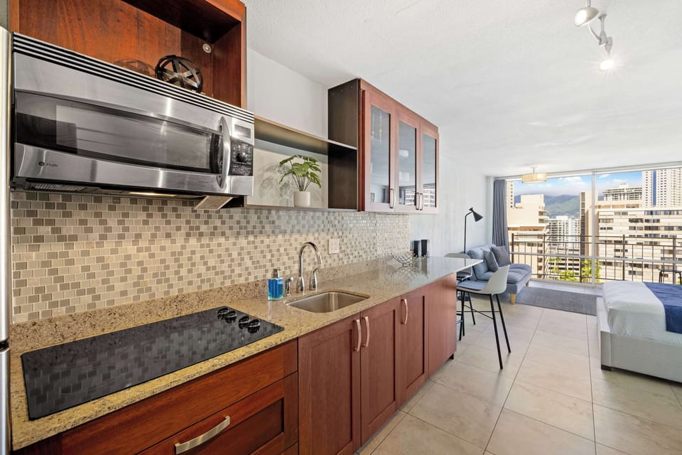 A cozy wooden kitchen featuring essential appliances and stocked wit some basics needed for cooking.