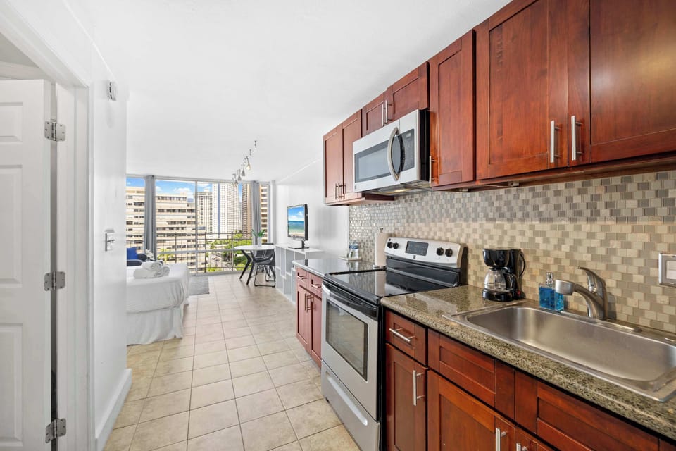 A cozy wooden kitchen featuring essential appliances and stocked wit some basics needed for cooking.
