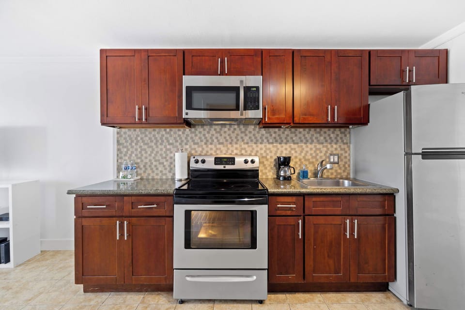 Modern kitchen with basic appliances, sleek counters, and stylish cabinetry