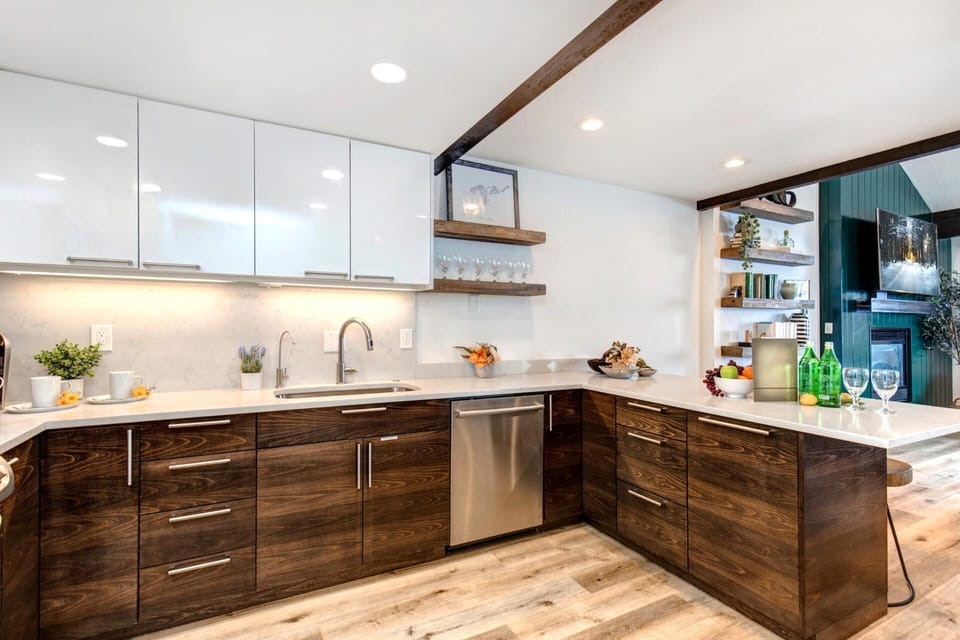 Modern kitchen blends sleek white cabinetry with rich wood textures.