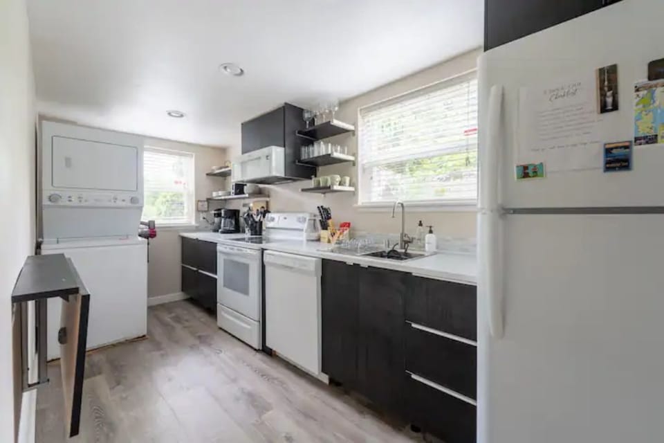 Galley Kitchen with microwave, oven, full refrigerator, dishwasher and laundry