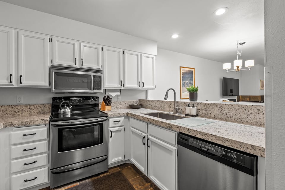 The well-equipped kitchen has stainless steel appliances and white cabinets.