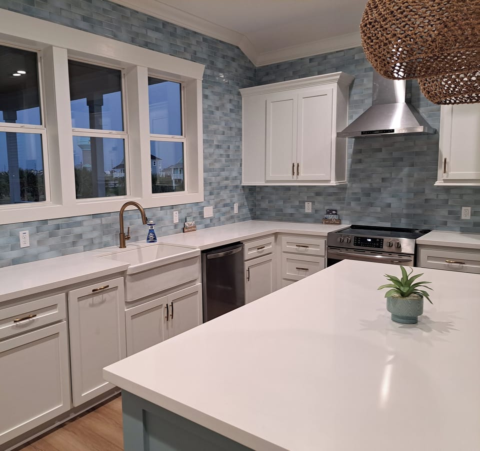 Stunning kitchen with view of back deck and palm paradise with lake views