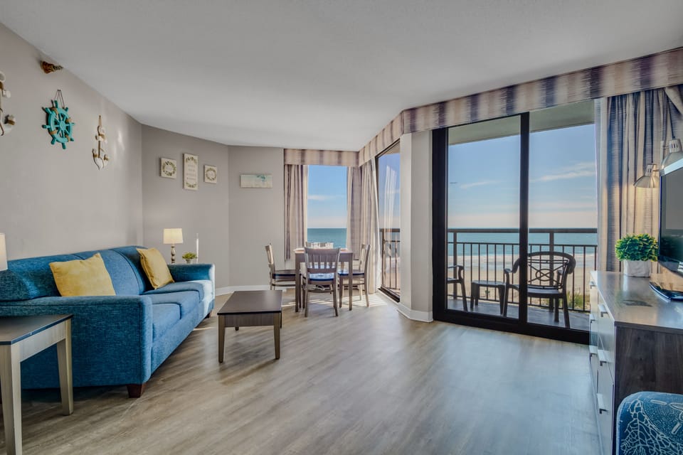 Discover a coastal comfort corner in the oceanfront suite's living area, where the plush couch invites relaxation, offering the perfect spot to enjoy the rhythmic sounds of the waves.