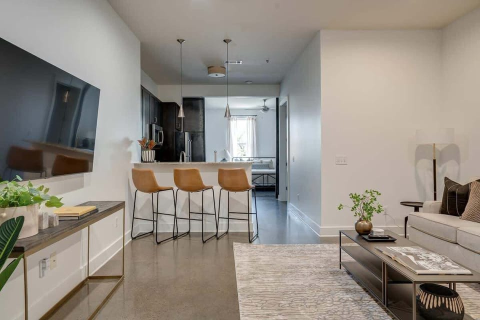 Open concept living area with designer furnishings and smart TV.