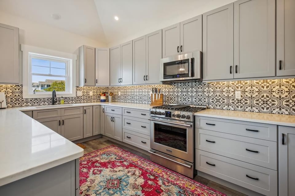 Step into this charming kitchen where artisan tiles add character above gleaming countertops. Cook your favorite meals on a professional-grade stove and enjoy ample cabinet space to store all your essentials.