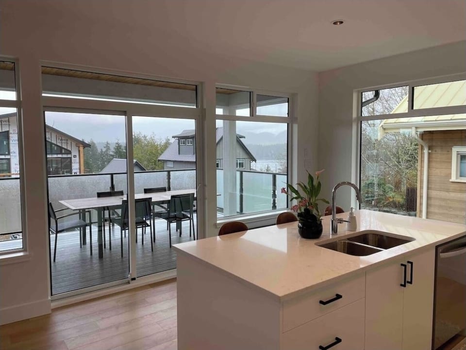 Open concept kitchen looking towards heated covered deck & peakaboo ocean views.