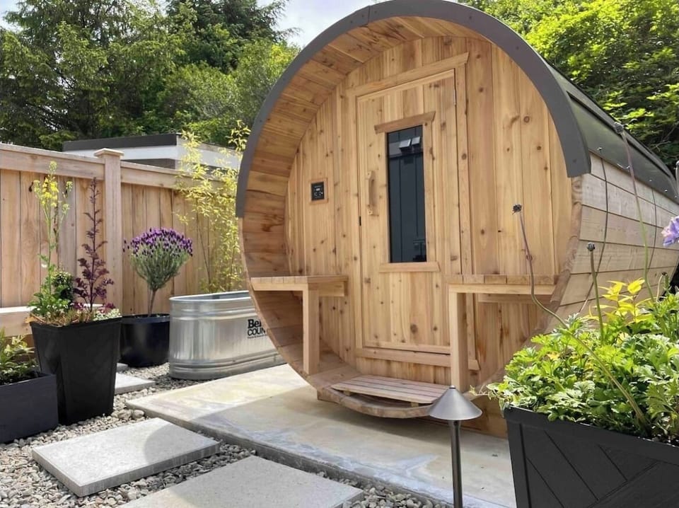 Western red cedar sauna with plunge tub and seating area.