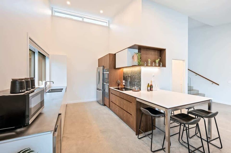 This sleek kitchen features top-of-the-line appliances, a wine fridge, and a coffee machine, perfectly complemented by easy access to the deck, where you can enjoy breathtaking views while dining.