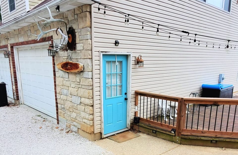 Blue door Entrance on side of garage facing pool.