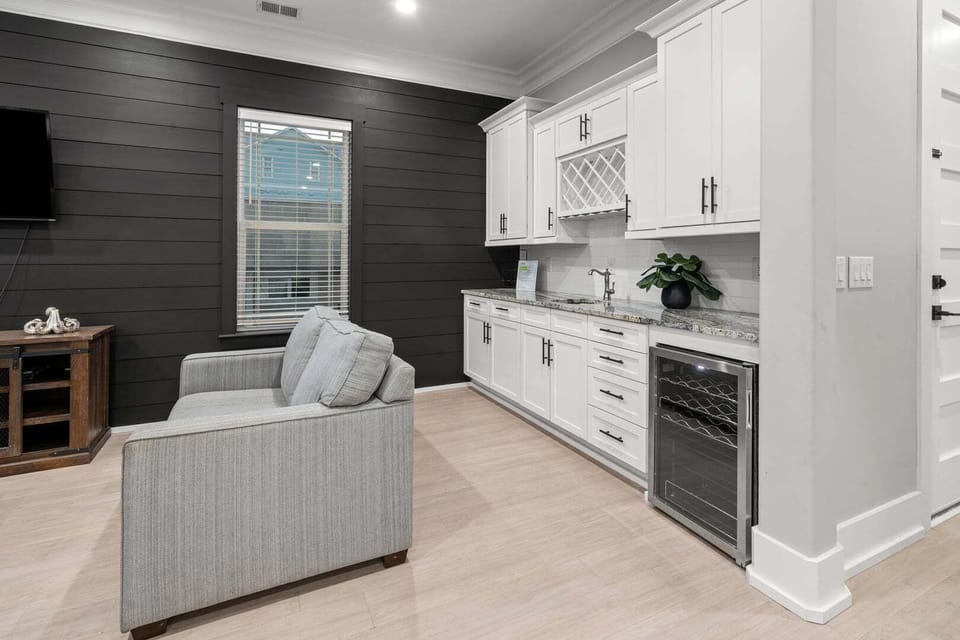 Lounge seating beside a wine fridge and pale cabinetry at Oceanside Charm, a Cherry Grove vacation rental